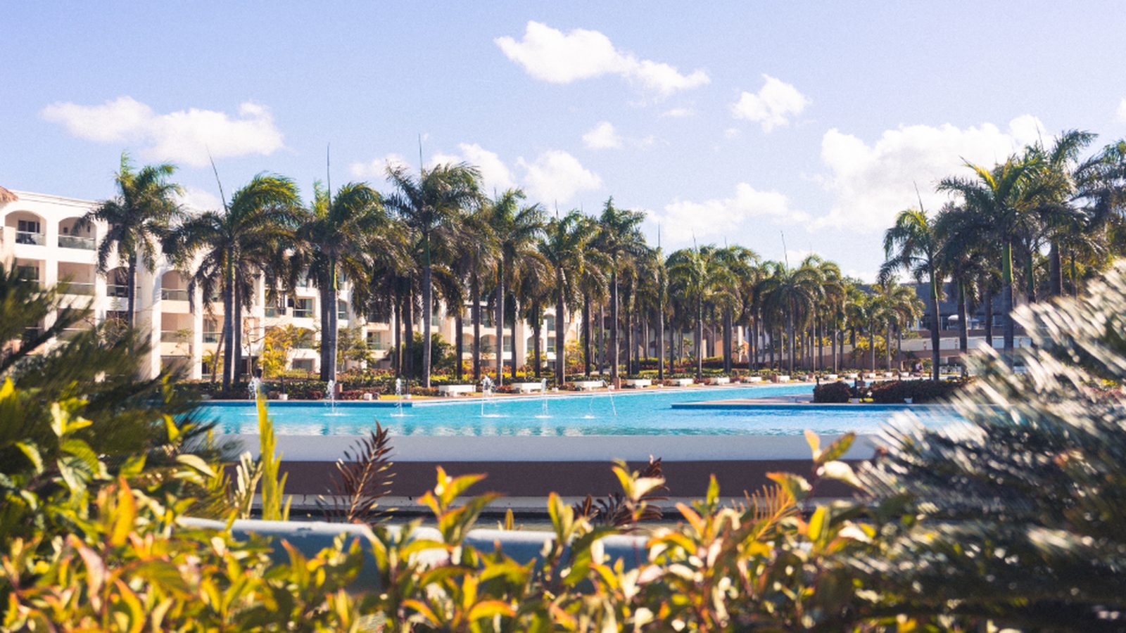 Casal relaxando na piscina de borda infinita de um resort ao pôr do sol